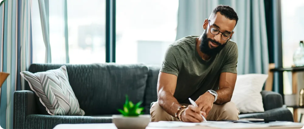 Man sitting at home filling in paperwork